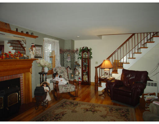 129 Walnut Hill Road Orange, MA 01364 - Photo 9 of 23 a living room with furniture a fireplace and a dining table with wooden floor