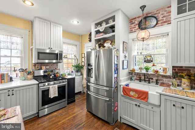 a kitchen with stainless steel appliances granite countertop a refrigerator a stove a sink and a window