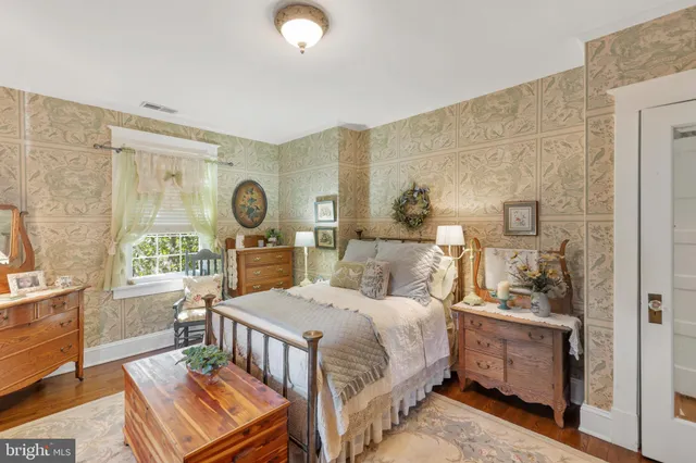 a bedroom with a bed and a dresser next to a window