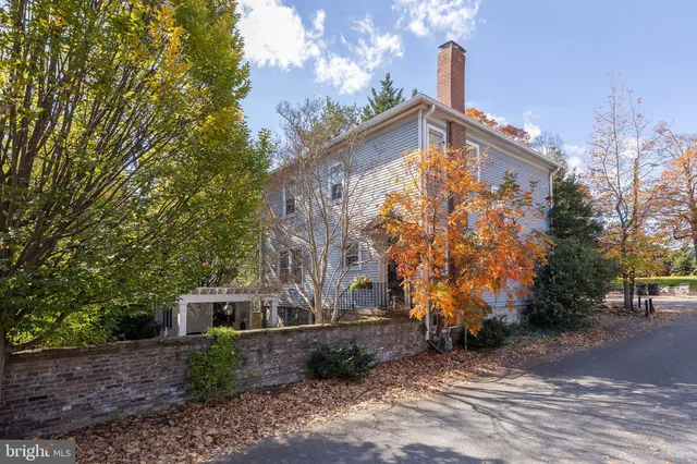 a view of a house with a small yard and wooden floor and fence