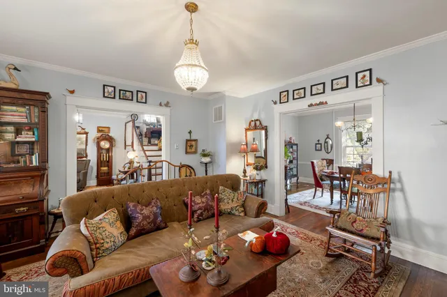 a living room with furniture kitchen and a chandelier