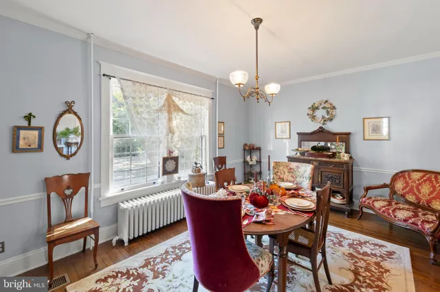 a dining room with furniture a rug a potted plant and a chandelier