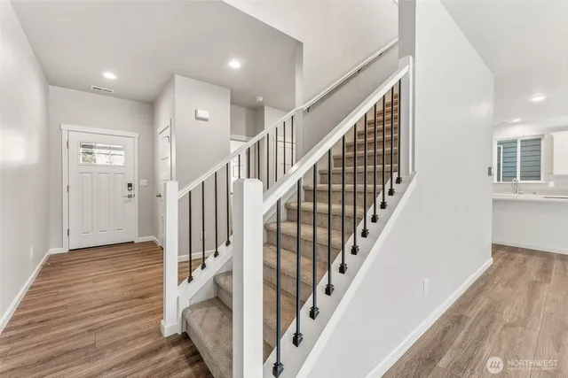 a view of entryway with wooden floor and stairs