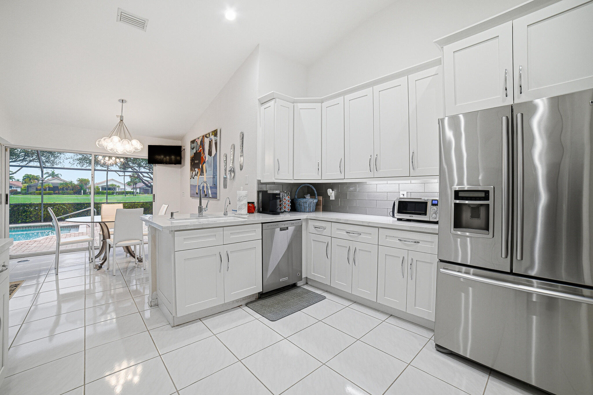 10791 River Glenn Drive Boca Raton, FL 33428 - Photo 22 of 68 a kitchen with white cabinets and refrigerator