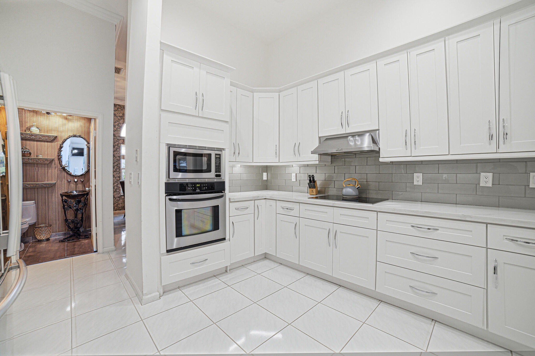 10791 River Glenn Drive Boca Raton, FL 33428 - Photo 24 of 68 a kitchen with granite countertop white cabinets and stainless steel appliances