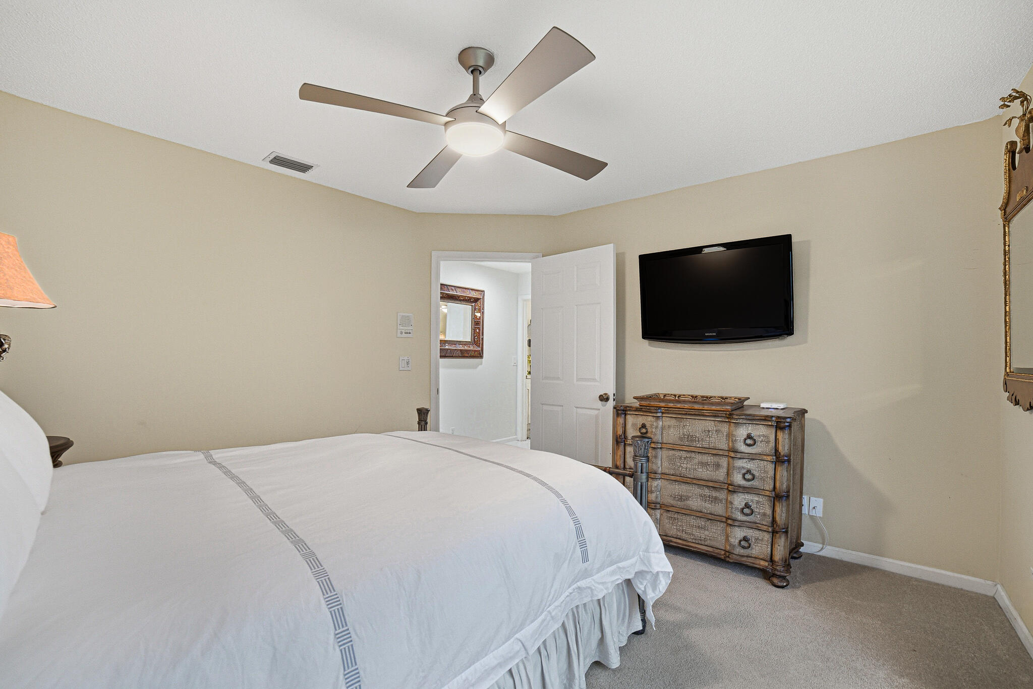 10791 River Glenn Drive Boca Raton, FL 33428 - Photo 38 of 68 a bedroom with a bed a flat screen tv and a chandelier