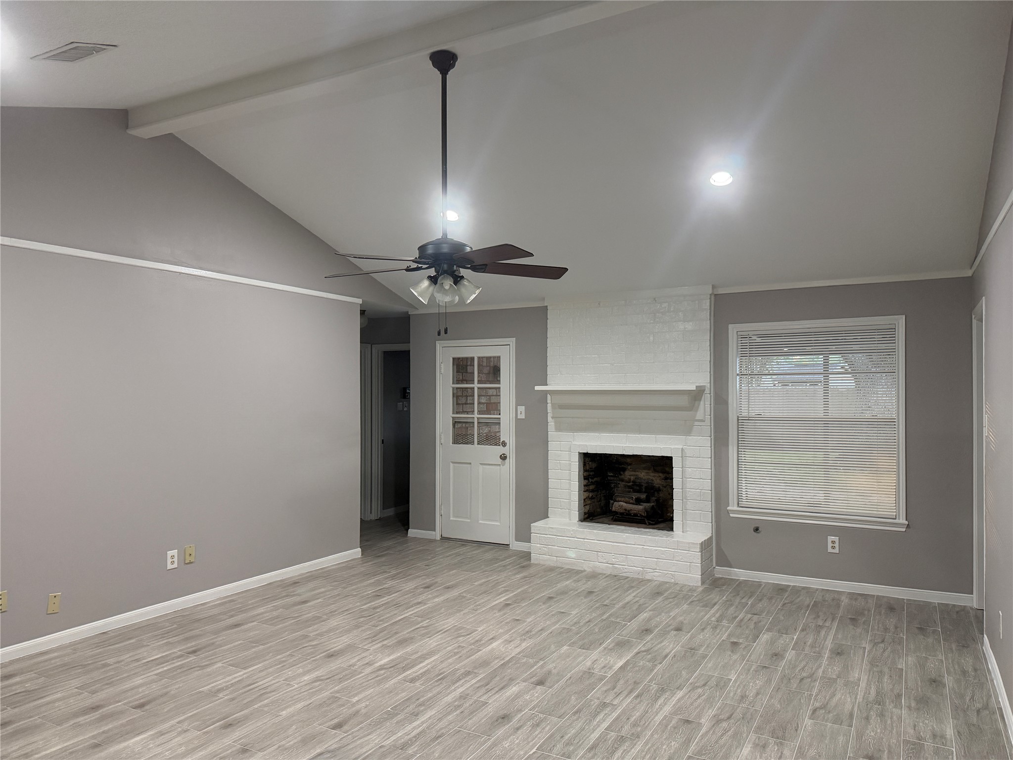 3815 Avenue R Rosenberg, TX 77471 - Photo 3 of 14 an empty room with windows fireplace and wooden floor