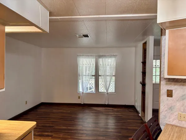 a view of a room with wooden floor and a window