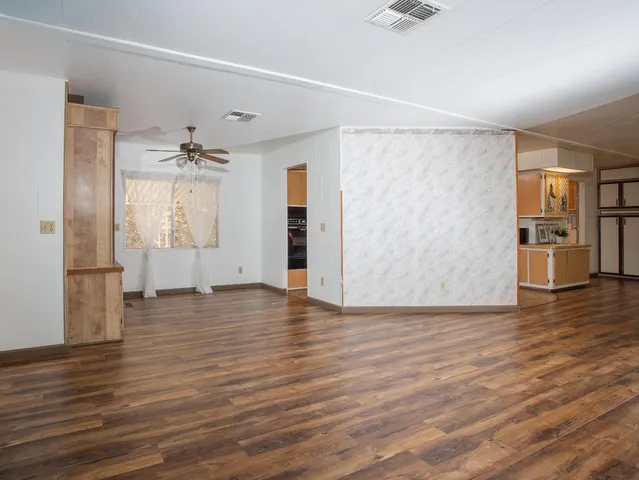 a view of an empty room with windows and closet