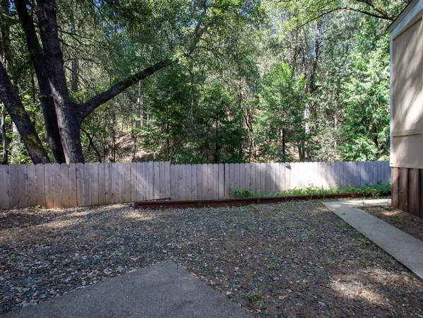 a view of a patio with table and chairs potted plants and large tree