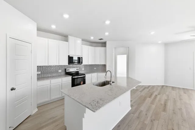 a view of kitchen with stainless steel appliances kitchen island a stove a refrigerator a sink and a stove