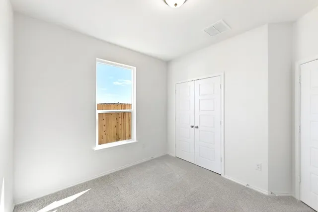 an empty room with windows and closet