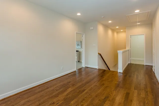a view of empty room with wooden floor and stairs