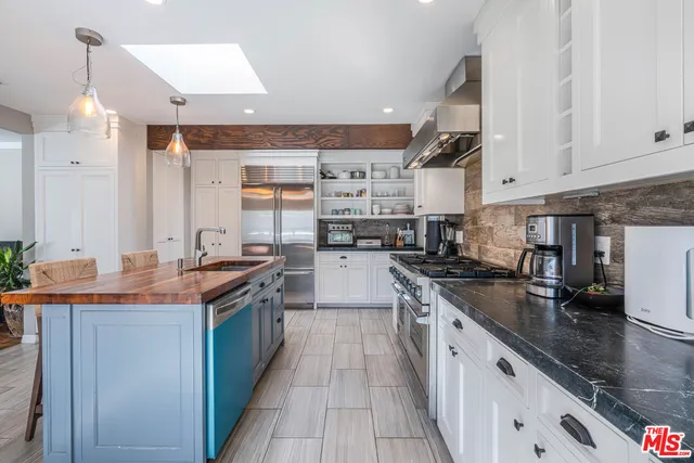 a kitchen with stainless steel appliances granite countertop a sink and a stove