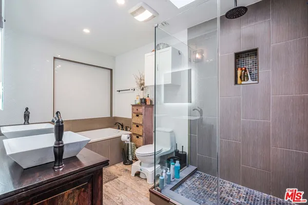 a bathroom with a tub sink and mirror