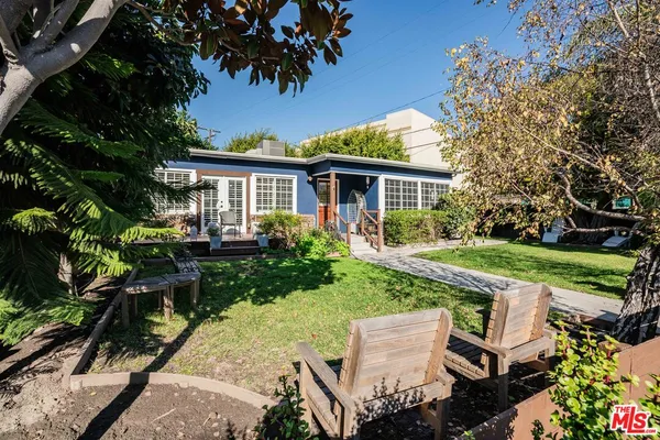 a view of backyard of house with green space and seating area