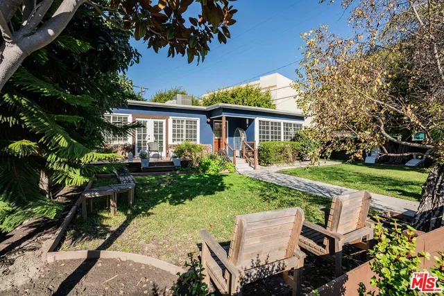 a view of backyard of house with green space and seating area