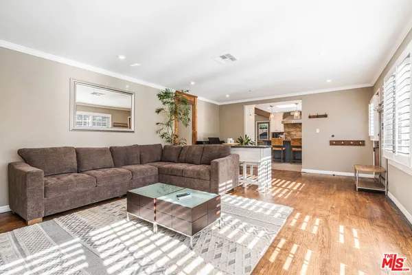 a living room with furniture and view of kitchen