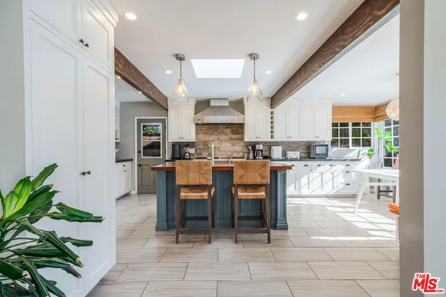 a open kitchen with granite countertop a table and chairs in it