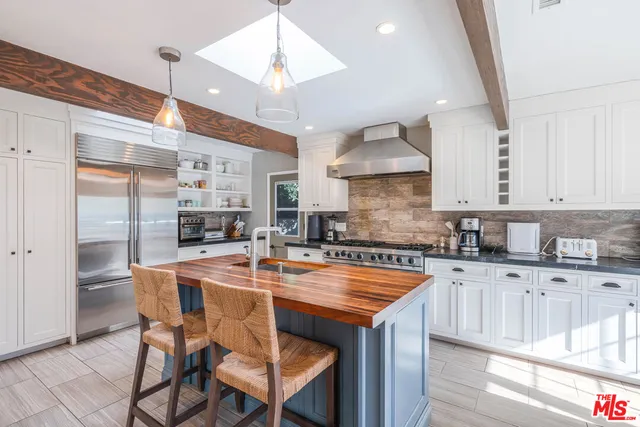 a kitchen with granite countertop a table chairs stove and cabinets