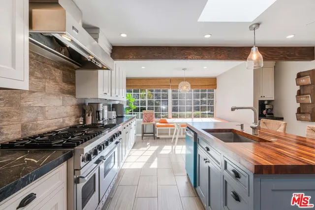 a kitchen with stainless steel appliances granite countertop a stove a sink and a microwave