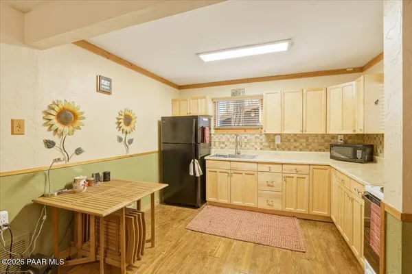 a kitchen with a sink refrigerator and cabinets