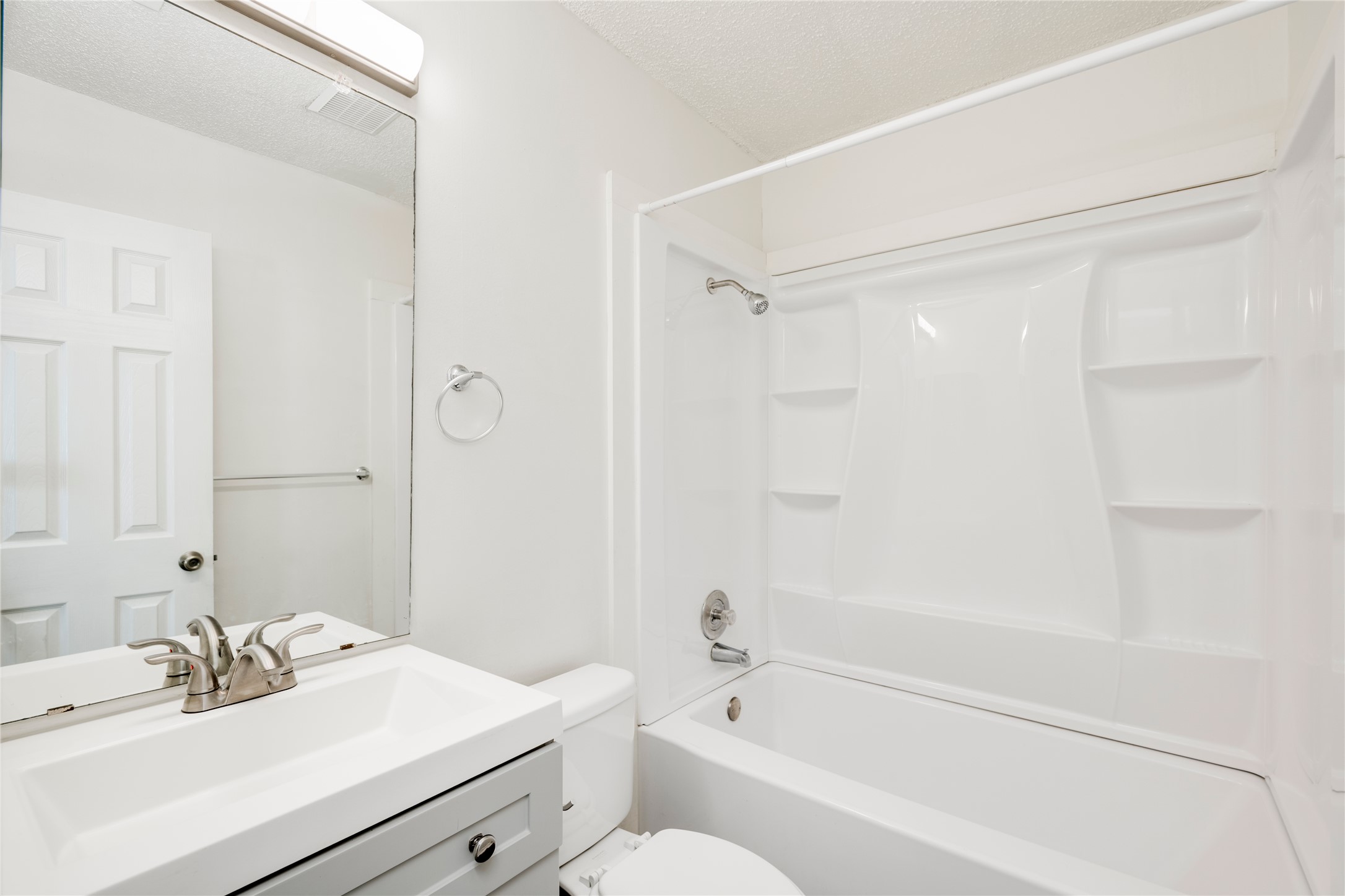 7918 West Gate Boulevard Austin, TX 78745 - Photo 9 of 31 A well-appointed bath features a shower-tub combination with built-in shelving, complemented by a sleek vanity.