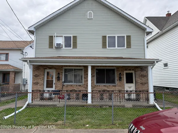 a view of a house with a yard and sitting area