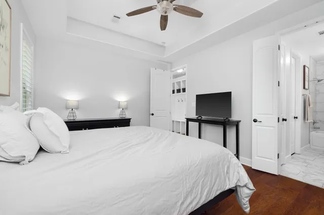 a bedroom with a bed and a flat tv screen on dresser