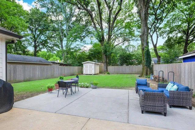 a view of house with garden and tall trees