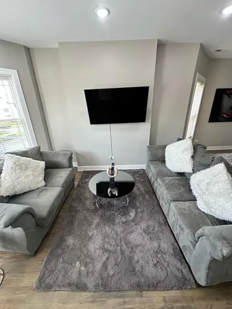 a living room with furniture and a wooden floor