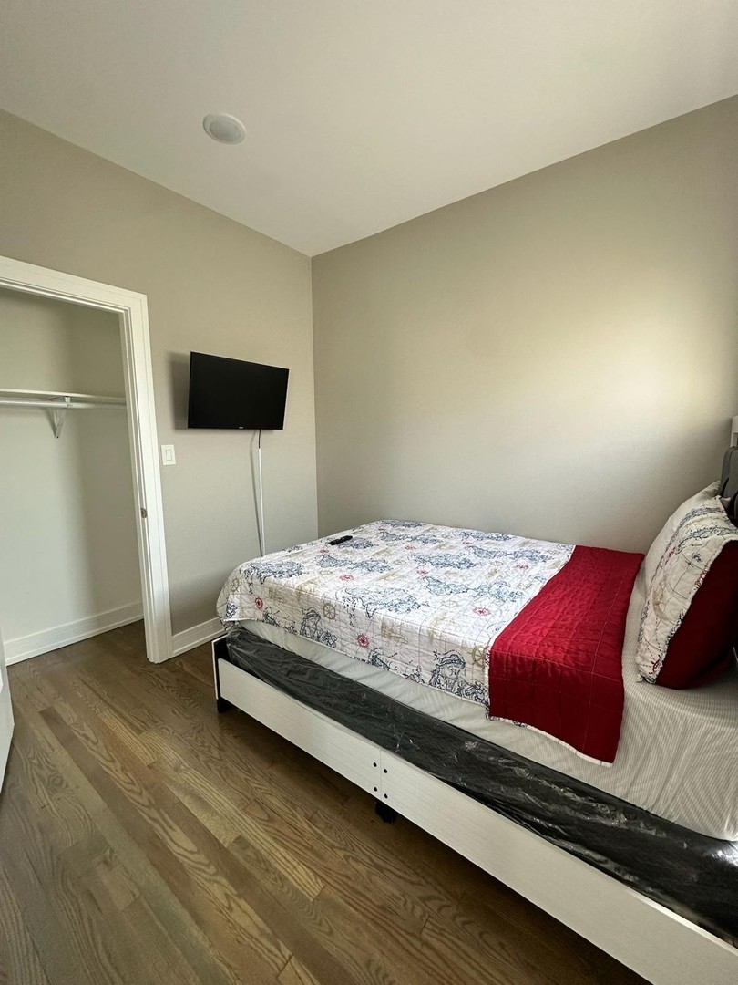 6807 South Calumet Avenue, Unit 2 Chicago, IL 60637 - Photo 7 of 12 a bedroom with a bed and a flat screen tv