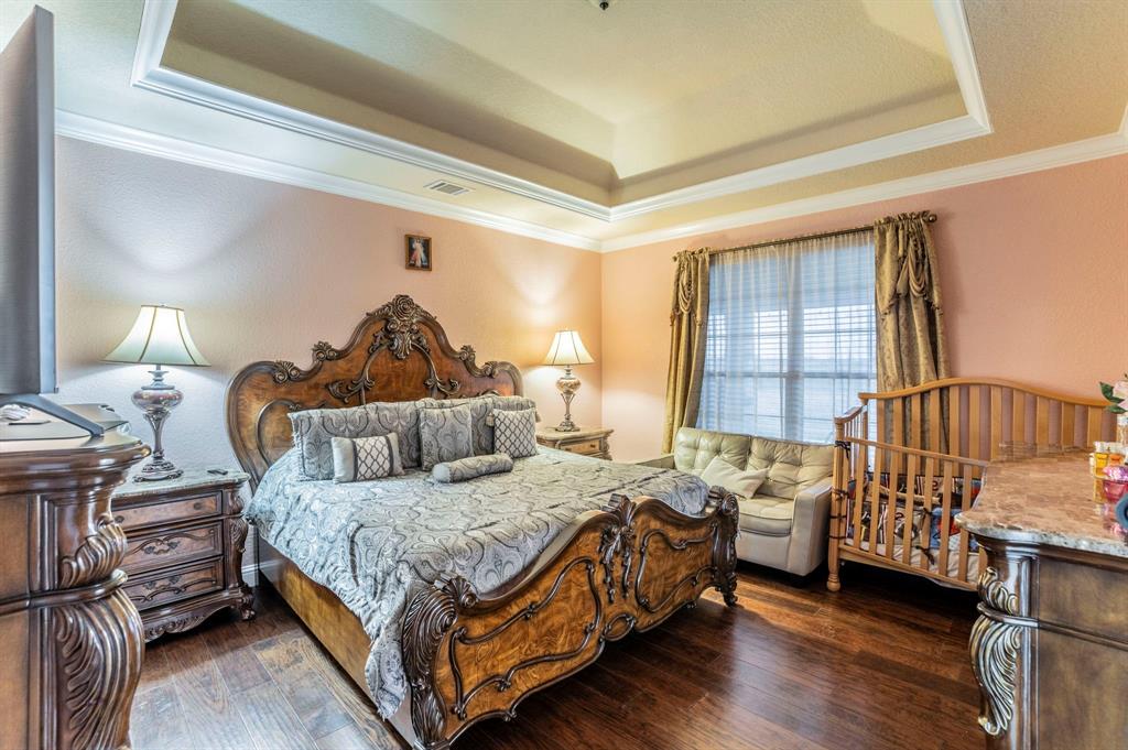 1019 Gin Road Ennis, TX 75119 - Photo 13 of 40 a bedroom with a bed and a chandelier