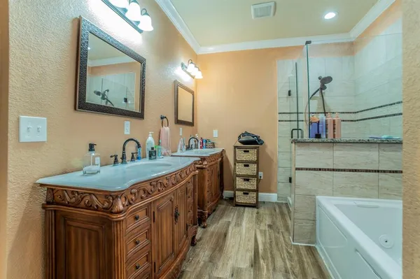 a bathroom with a granite countertop sink a mirror a bathtub and a shower
