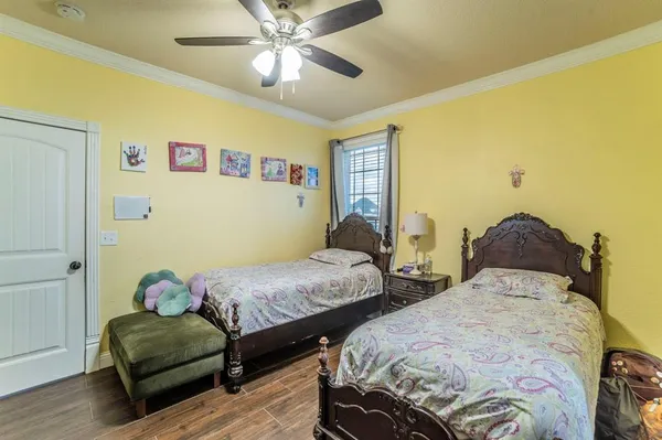 a bedroom with two beds and wooden floor
