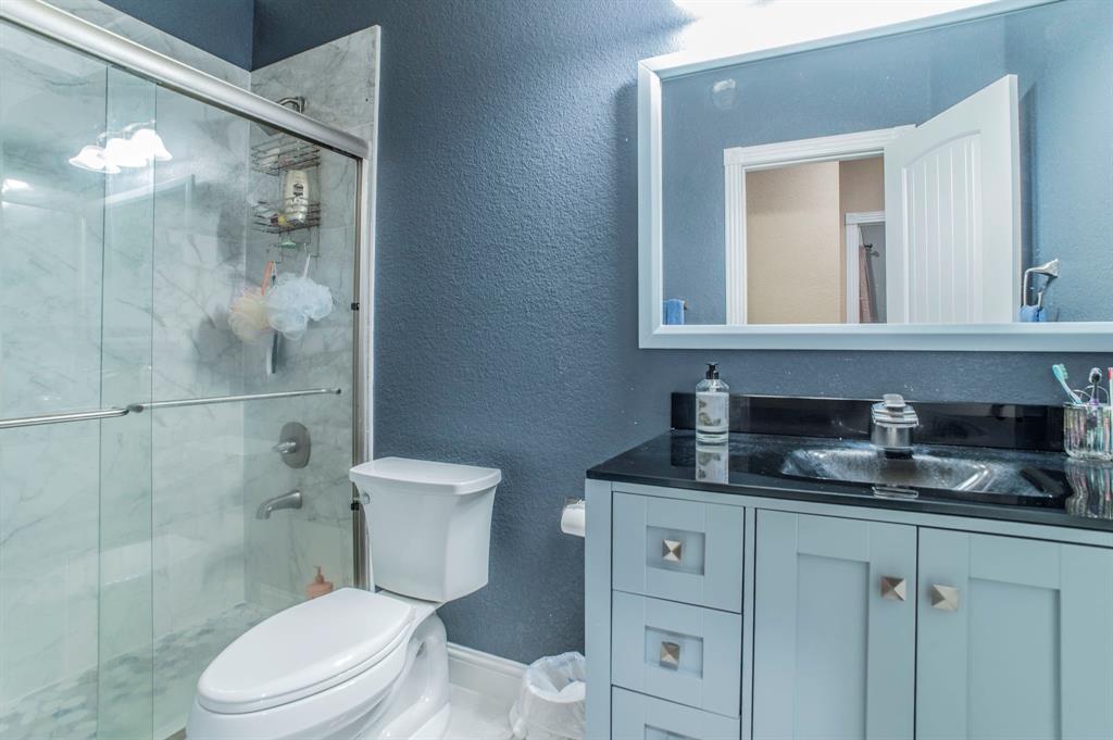 1019 Gin Road Ennis, TX 75119 - Photo 23 of 40 a bathroom with a granite countertop toilet sink and mirror