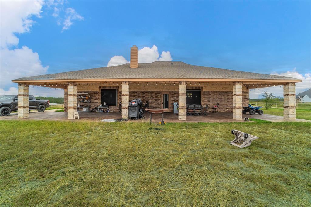 1019 Gin Road Ennis, TX 75119 - Photo 32 of 40 a view of a house with floor to ceiling windows and a yard