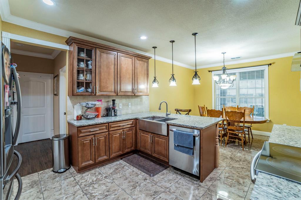 1019 Gin Road Ennis, TX 75119 - Photo 5 of 40 a kitchen with stainless steel appliances granite countertop a sink a stove and a refrigerator