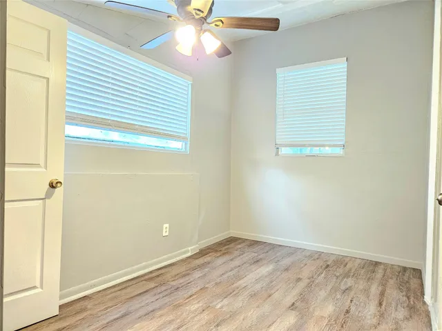 an empty room with a window and wooden floor