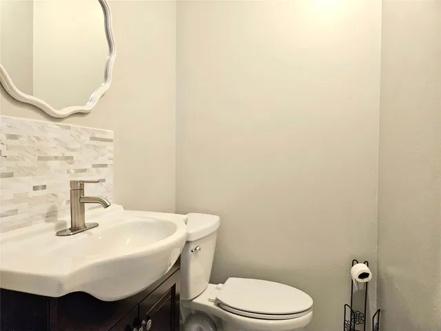 a bathroom with a sink a toilet and mirror