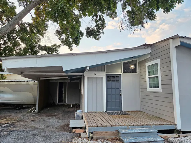 a view of a house with a door and wooden fence