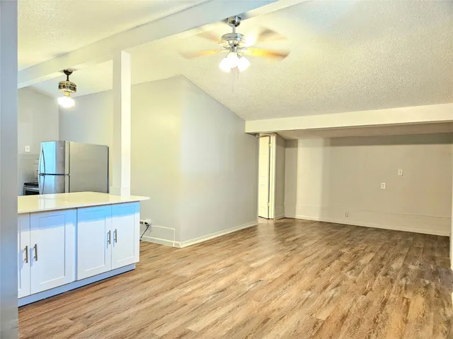 a view of a kitchen with wooden floor and a chandelier fan