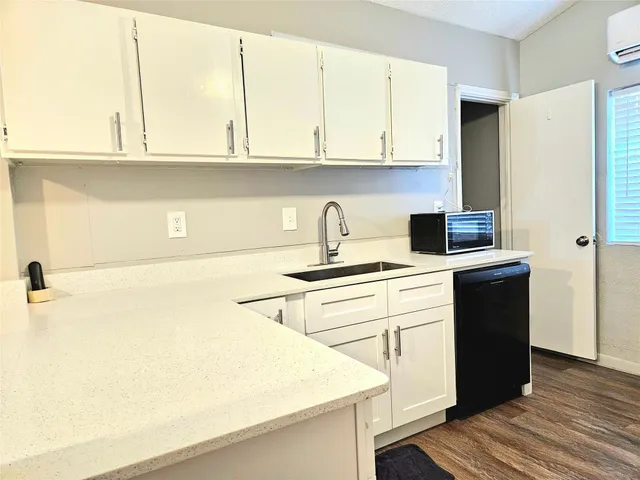 a kitchen with stainless steel appliances white cabinets and a refrigerator