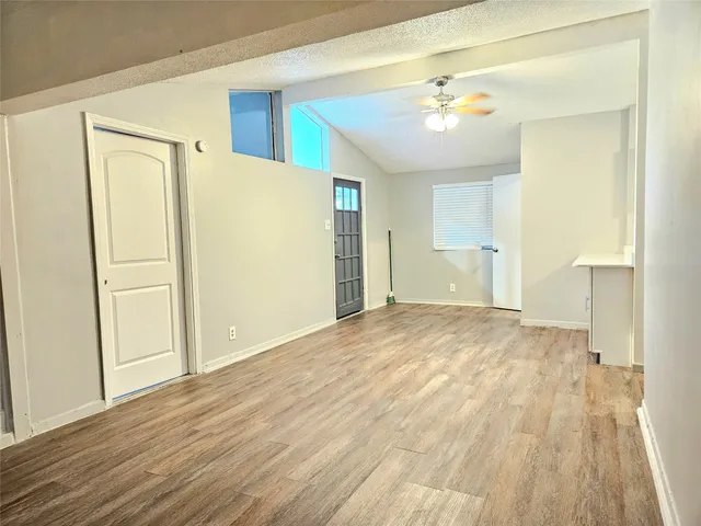 a view of empty room with wooden floor