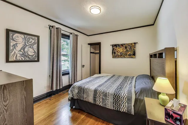 a bedroom with a bed and wooden floor