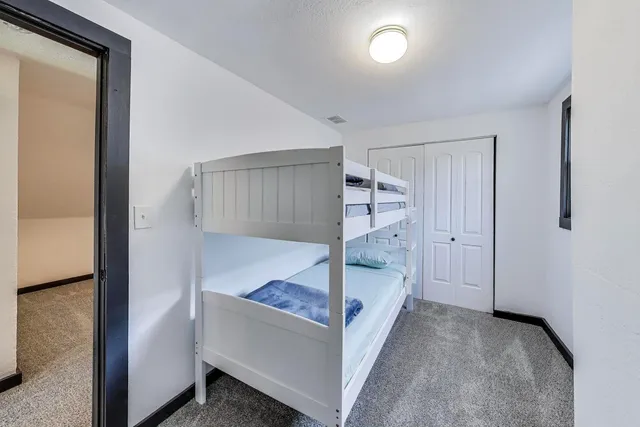 a view of a room with a hanging light and kitchen view