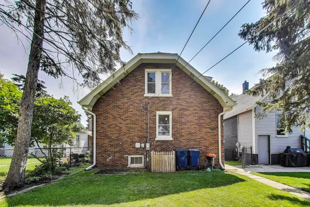 a view of a yard with large trees and a wooden fence