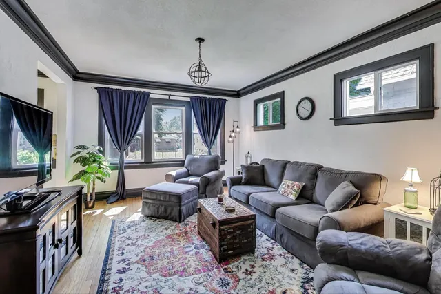 a living room with furniture a large window and a flat screen tv