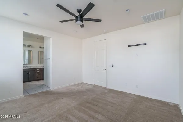 an empty room with a window and a fan