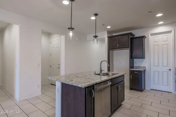a kitchen with stainless steel appliances granite countertop a sink a stove a refrigerator and cabinets